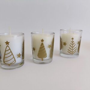 White votive candle in Christmas themed glass candle holder