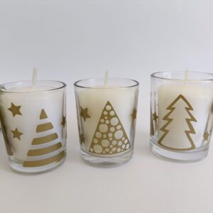 White votive candle in Christmas themed glass candle holder