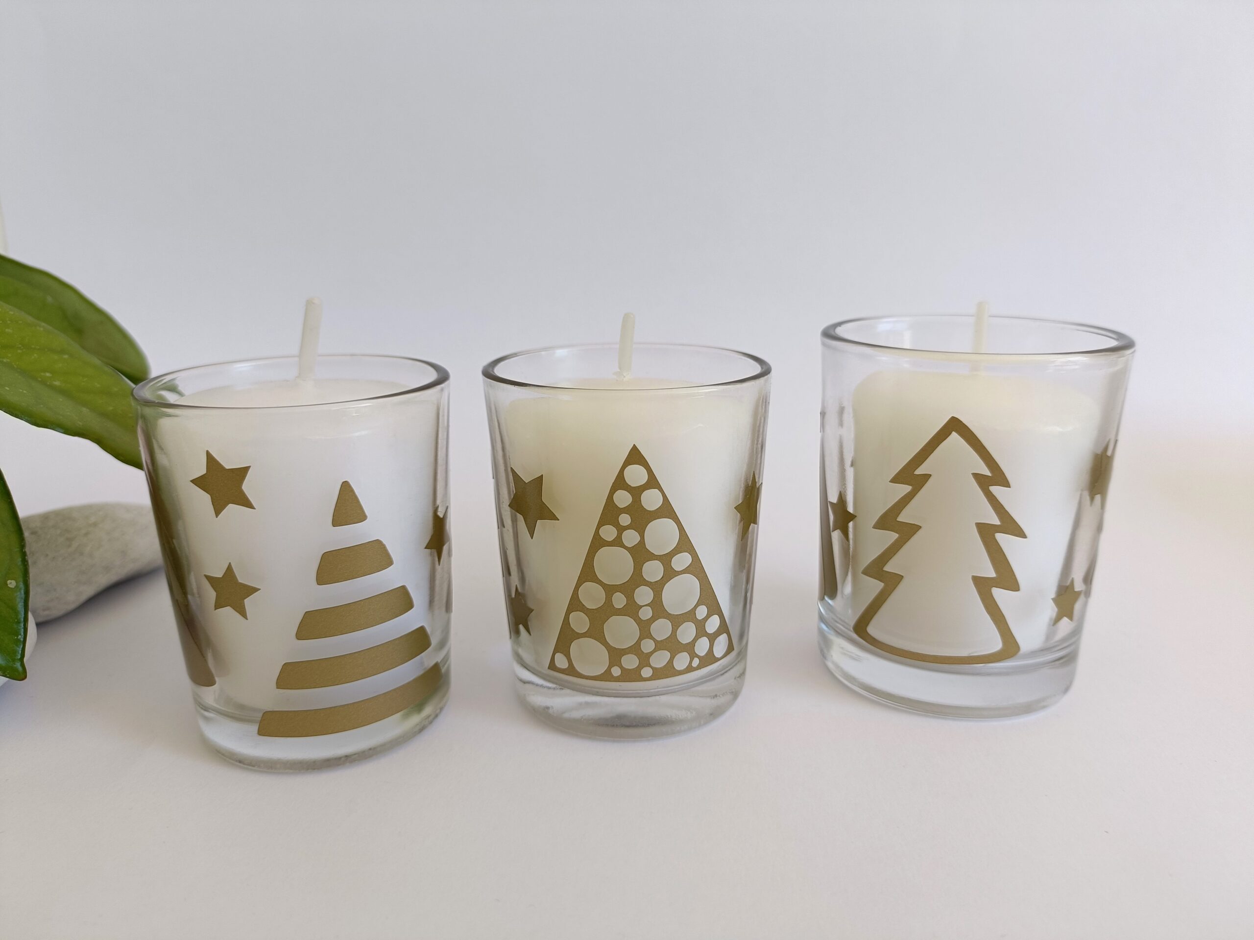 White votive candle in Christmas themed glass candle holder